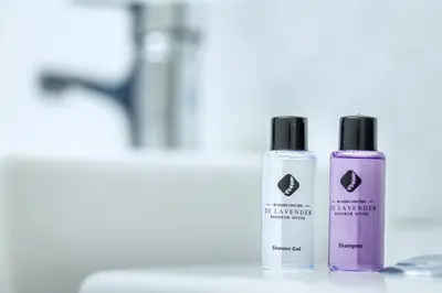 two bottles of essential oils sitting on a bathroom counter at De Lavender Bangkok Hotel in Bangkok