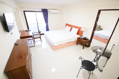 a hotel room with a bed and a mirror at White House Bizotel in Bangkok