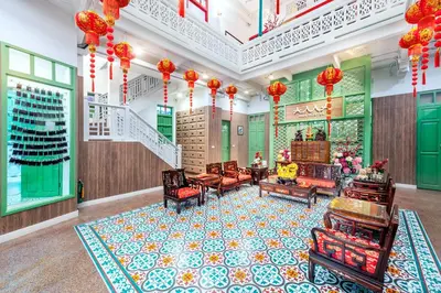 a room with chairs and a staircase in a building at Ama Hostel Bangkok in Bangkok