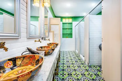 a row of sinks in a bathroom with mosaic tiles at Ama Hostel Bangkok in Bangkok