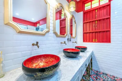 two sinks in a bathroom with red and white walls at Ama Hostel Bangkok in Bangkok
