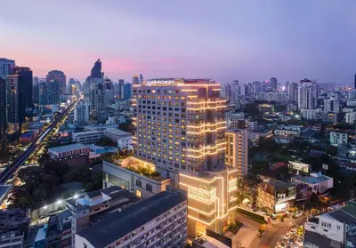 a lit up building in a city at night at Hotel Nikko Bangkok in Bangkok