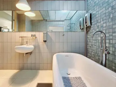 a bathroom with a bath tub and a sink at Somewhere to Escape - Hometel in Bangkok
