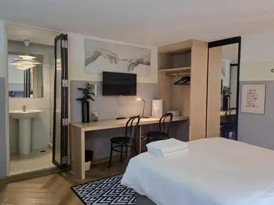 a bedroom with a bed and a desk with a computer at Somewhere to Escape - Hometel in Bangkok