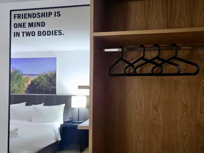 a hotel room with a bed and a sign on the door at Somewhere to Escape - Hometel in Bangkok