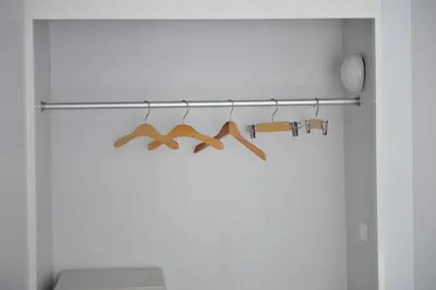 a closet with a rack with four wooden at Drop Inn Bangkok in Bangkok