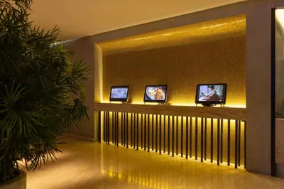 a room with four monitors on a wall with at LiT BANGKOK Hotel in Bangkok