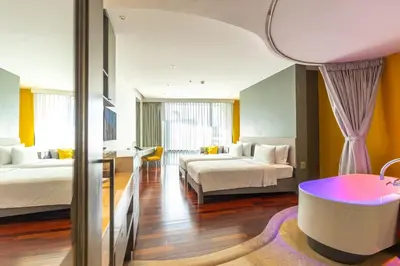 a hotel room with two beds and a tub at LiT BANGKOK Hotel in Bangkok