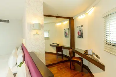 a room with a bed and a desk and a mirror at LiT BANGKOK Hotel in Bangkok
