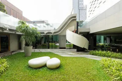 two white objects on the grass in front of a building at LiT BANGKOK Hotel in Bangkok