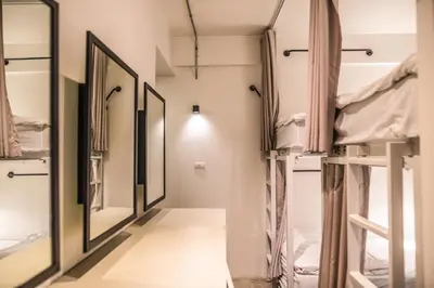 a hallway with multiple bunk beds and mirrors at Jam Hostel Bangkok in Bangkok