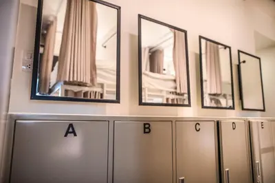 a row of mirrors on a wall above cabinets at Jam Hostel Bangkok in Bangkok
