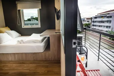 a small bedroom with a bed on a balcony at Jam Hostel Bangkok in Bangkok