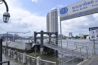 a street sign next to a river with a building at New Siam III Guest House in Bangkok