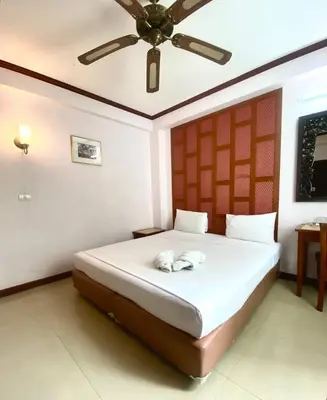 a bedroom with a bed with a ceiling fan at New Siam III Guest House in Bangkok