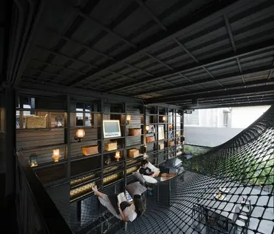 two people sitting in chairs in a room at Kloem Hostel in Bangkok
