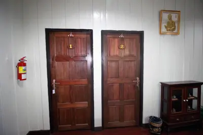 two wooden doors in a room with a table at OB ARUN House in Bangkok