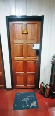 a wooden door with a rug in front of it at OB ARUN House in Bangkok