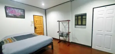 a small bedroom with a bed and a door at OB ARUN House in Bangkok