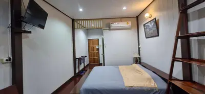 a small room with a bed and a television at OB ARUN House in Bangkok