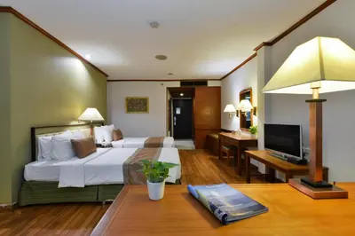 a hotel room with two beds and a television at Arawana Regency Park Sukhumvit in Bangkok