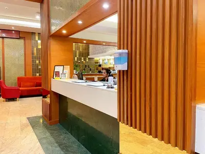 a woman sitting at a counter in a restaurant at Arawana Regency Park Sukhumvit in Bangkok