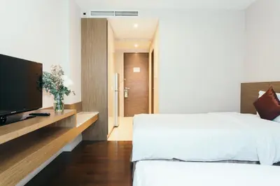 a bedroom with a bed and a flat screen tv at Thomson Residence Hotel in Bangkok
