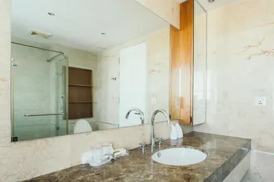 a bathroom with a sink and a shower at Thomson Residence Hotel in Bangkok