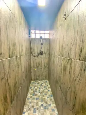 a bathroom with a shower and a tiled floor at 4J Lodge in Bangkok
