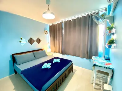 a blue bedroom with a bed and a window at 4J Lodge in Bangkok
