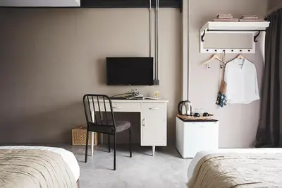 a bedroom with a desk with a television and a bed at Ob-Oon Boutique Bed & Breakfast in Bangkok