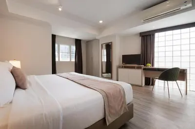 a bedroom with a bed and a desk with a computer at Aspira Residence Ruamrudee in Bangkok