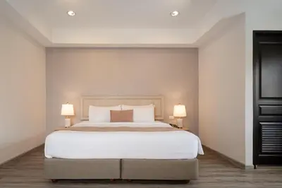 a bedroom with a large bed with two lamps at Aspira Residence Ruamrudee in Bangkok