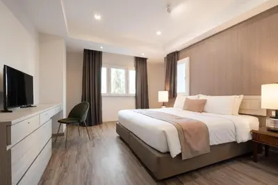 a bedroom with a large bed and a television at Aspira Residence Ruamrudee in Bangkok