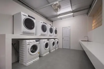 a laundry room with four washer and dryers in it at Aspira Residence Ruamrudee in Bangkok