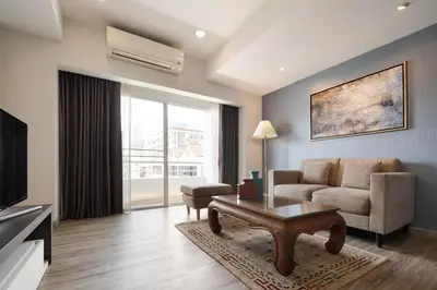 a living room with a couch and a table at Aspira Residence Ruamrudee in Bangkok