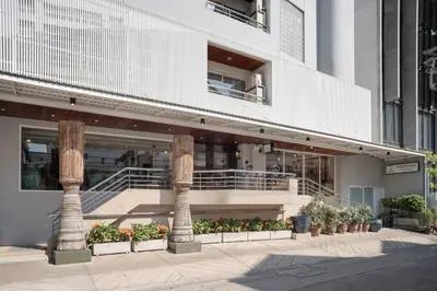 a building with columns and plants in front of it at Aspira Residence Ruamrudee in Bangkok