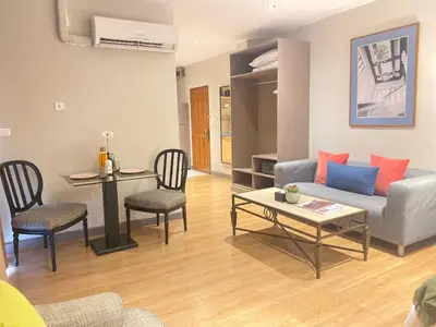 a living room with a couch and a table and chairs at Asoke Residence Sukhumvit by UHG in Bangkok