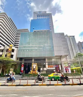 a building with people riding motorcycles in front of it at Asoke Residence Sukhumvit by UHG in Bangkok