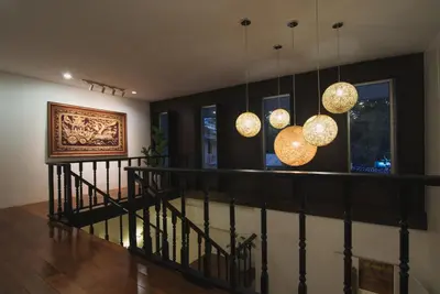 a hallway with a staircase with chandeliers at Siam Nitra Boutique Hotel in Bangkok
