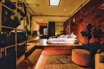 a bedroom with a bed and a brick wall at Siam Nitra Boutique Hotel in Bangkok