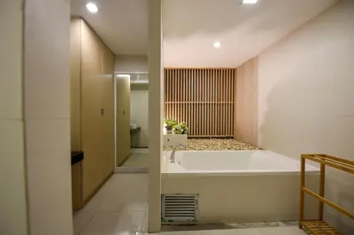 a bathroom with a bath tub and a sink at Siam Nitra Boutique Hotel in Bangkok