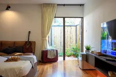 a living room with a bed and a television at Siam Nitra Boutique Hotel in Bangkok