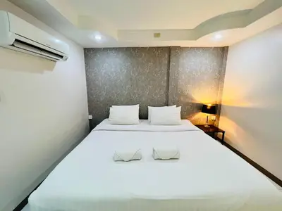 a bedroom with a large white bed with two slippers at Bed by Tha-Pra SHA Plus in Bangkok