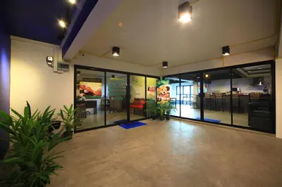 a lobby with glass doors and plants in a building at Tuk Tuk Hostel in Bangkok