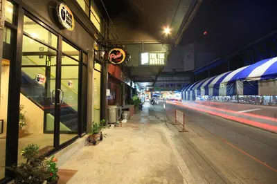 a train is passing through a train station at night at Tuk Tuk Hostel in Bangkok