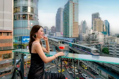 a woman standing on a balcony with a drink at The Westin Grande Sukhumvit, Bangkok in Bangkok