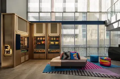 a living room with a couch and a large window at Aloft Bangkok - Sukhumvit 11 in Bangkok
