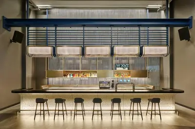 a bar in a restaurant with stools around it at Aloft Bangkok - Sukhumvit 11 in Bangkok