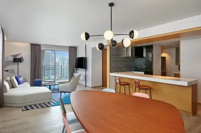a living room and kitchen with a table and chairs at Aloft Bangkok - Sukhumvit 11 in Bangkok